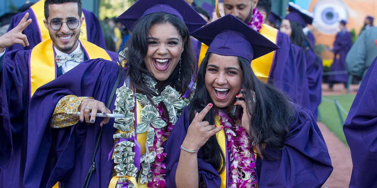 Photo of several graduates at 2019 Commencement smiling at the camera